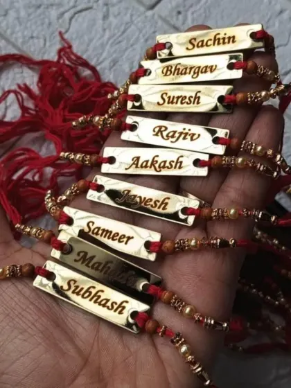 A handful of my popular metal name rakhis, each engraved with a different name in a stylish font. These are durable and can be kept long after the festival.