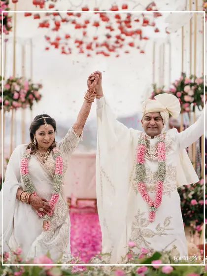 A moment of shared victory and happiness as the couple raises their hands after the wedding ceremony.