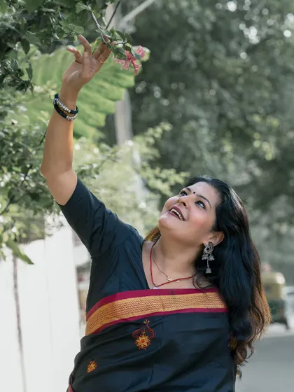 A whimsical shot, reaching for flowers. It shows a softer, more romantic side to ethnic styling.