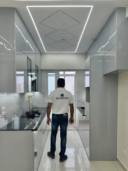 A shot from the back, showing the full effect of the reflective high-gloss cabinets and the modern ceiling light design. This kitchen is a perfect example of our commitment to quality and style.