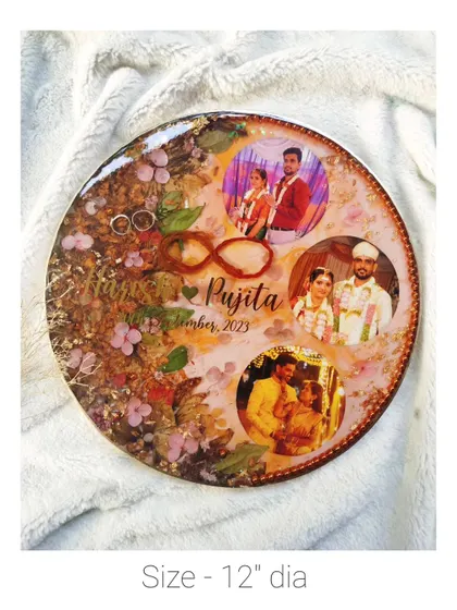 A 12-inch round frame featuring a collage of three wedding photos, along with preserved flowers and rings.