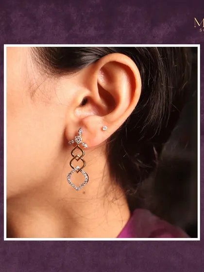 A closer look at these uniquely crafted diamond drop earrings. The interlocking shapes and mix of gold tones create a design that is modern, elegant, and perfect for elevating any outfit.