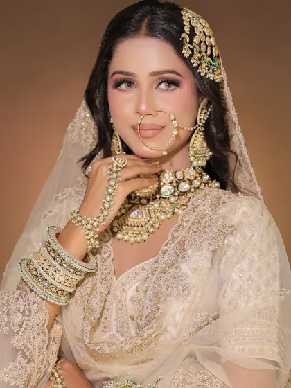 A detailed shot of the pearl white lehenga, focusing on the stunning oversized necklace and passa, which are also available for rent.
