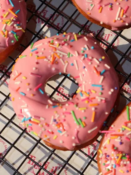 A perfect shot of our pink sprinkle donut, showing off its glossy glaze and fun colors.