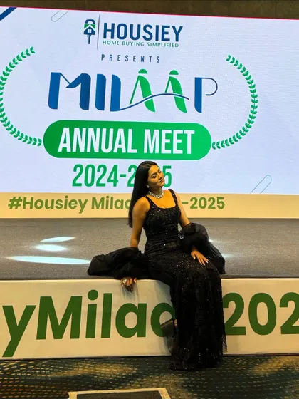 Sitting on the edge of the stage at the Housiey event. This informal pose shows my approachable style, even in a formal setting.