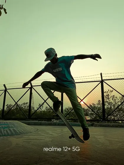 A silhouette of a skateboarder against the setting sun. The colors of the sunset create a beautiful gradient in the sky, highlighting the athlete's form.