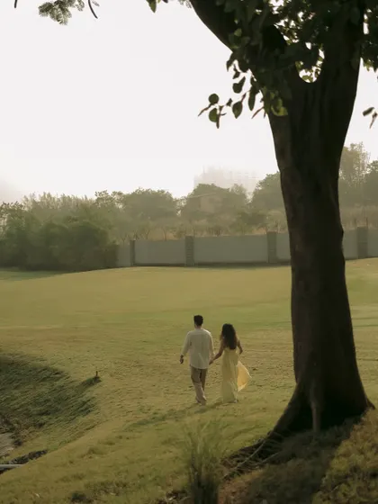 A quiet walk through a green field, this wide shot creates a sense of peace and solitude for the couple.