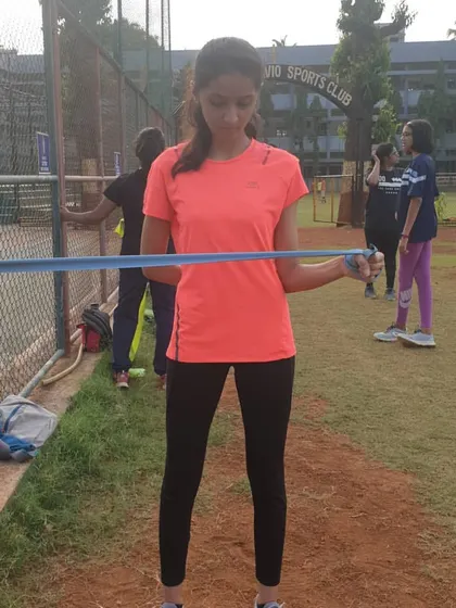 This image shows the external rotation phase of a theraband exercise. This movement specifically targets the rotator cuff muscles, helping to prevent common shoulder injuries in athletes.