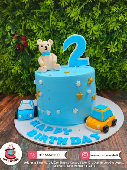 A sweet blue cake for a 2nd birthday, decorated with a teddy bear and toy cars. It's a simple and adorable theme for a little boy.