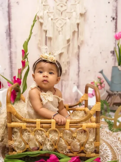 A classic half-birthday portrait with a rustic, bohemian floral theme. The '1/2' sign and natural props create a timeless look.