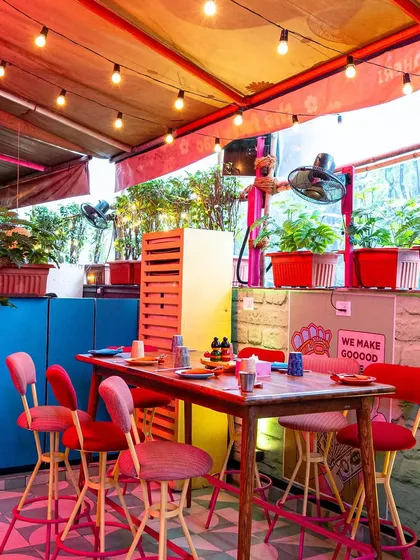 The outdoor terrace at The Fatty Bao, with its colorful furniture and string lights. This photo captures the casual, festive atmosphere of the al fresco dining area, perfect for evening service.
