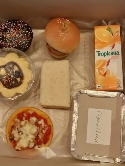 This photo shows the variety of treats in my kids' snack boxes, including a soft chicken slider bun and a fun flower-shaped cookie. It’s a complete, no-fuss meal for any kids' party.