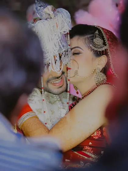 A heartfelt hug amidst the crowd. This candidly framed shot captures a private moment of overwhelming emotion and joy, making it a powerful and authentic memory from their wedding day.