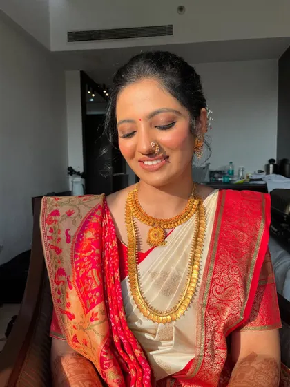 A smiling portrait showing the complete look. The makeup is fresh and radiant, and the unique saree drape symbolizes the union of two cultures.