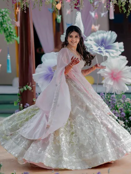 The bride is a vision in pastel at her Mehendi ceremony. The decor, with its giant paper flowers and whimsical origami birds, brought her Pinterest board to life.