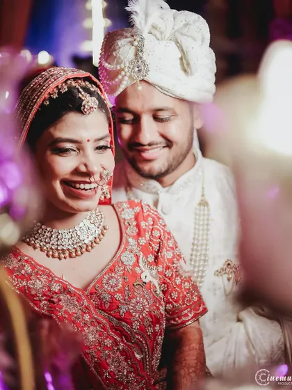 A candid moment of laughter between the bride and groom, captured through a soft foreground blur that adds an artistic touch.
