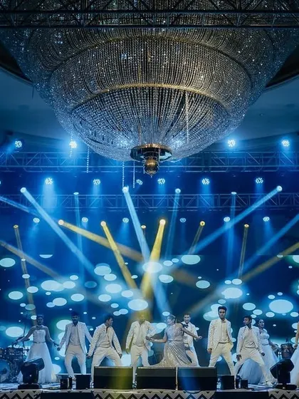 A spectacular performance on the Sangeet stage, with the giant ballroom chandelier and dynamic lighting creating a truly cinematic moment.
