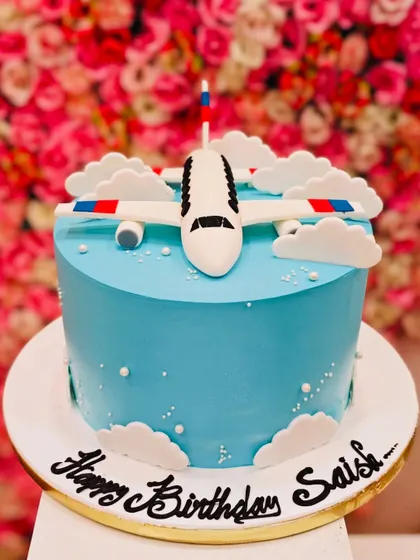 An aeroplane theme cake with a fondant plane flying above the clouds. It's a great choice for a future pilot or any child who loves planes.