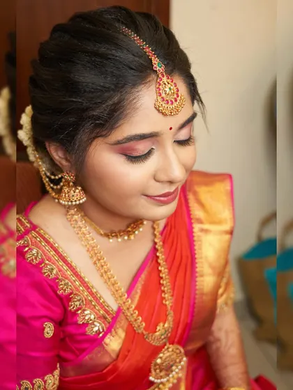 Vidhatri looking beautiful for her wedding ceremony. The pink and orange saree is a popular and stunning choice for South Indian brides.