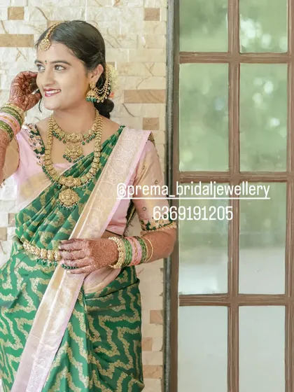 A full view of the bride's outfit, showing how the vaddanam and necklaces complete her traditional look.