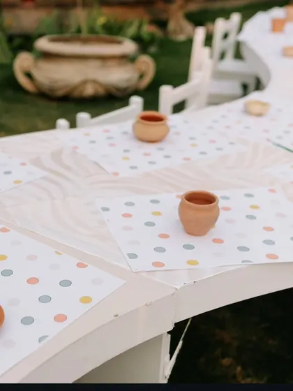 A close-up of the kids' activity table, with mini terracotta pots ready for painting, providing a fun and hands-on experience.