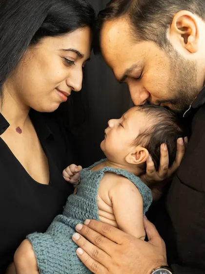 A father's tender kiss for his sleeping baby. These are the moments you'll want to remember forever, and I am honored to capture them for you.
