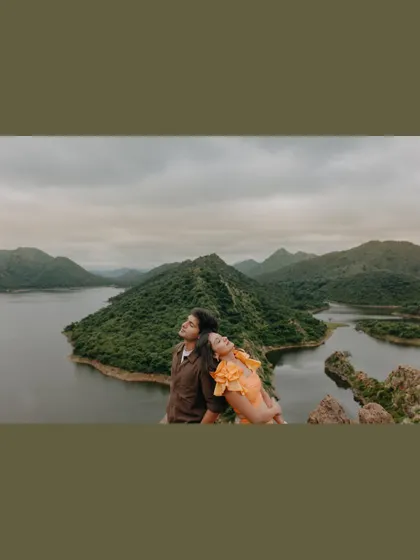 A moment of peaceful rest overlooking the serene lakes and hills of Udaipur. This destination pre-wedding shot captures the tranquility of the landscape.