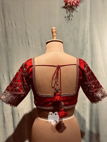 The back of the red silk blouse, with its deep U-back and delicate tie-up tassels.