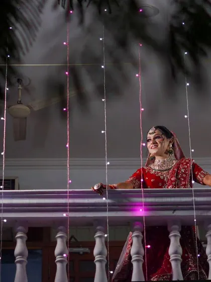 A beautiful candid moment of the bride on her balcony, surrounded by fairy lights. This shot captures her happy anticipation before the main event, creating a lovely, natural portrait.