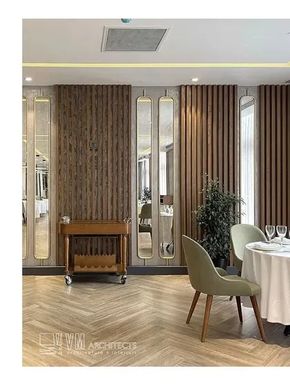 The dining space at Shebran Wellness Resort features elegant interior design with custom wood paneling, herringbone floors, and soft lighting. The design creates an intimate and upscale dining atmosphere that complements the resort's overall focus on refined wellness.