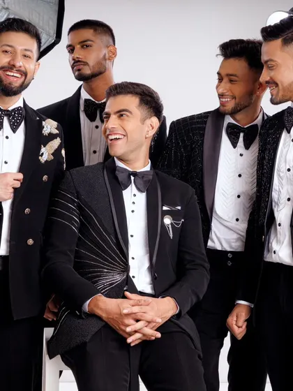A candid moment from our tuxedo photoshoot, showing the variety of styles and details we offer, from unique bow ties to embellished jackets.