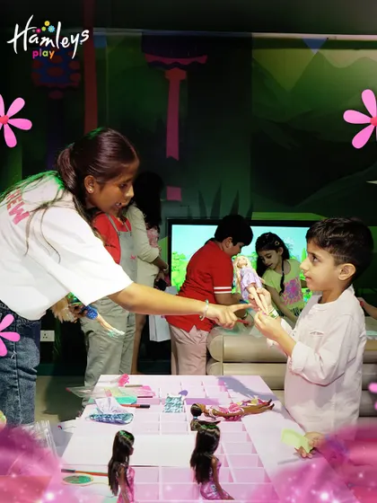 During our Barbie-themed party, every child gets to play and create. A Play Pal is seen here helping a young boy choose a doll for a styling session at our pop-up Barbie Style Studio.