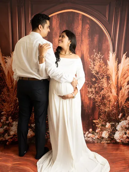 A classic couple's pose against a rustic backdrop. The contrast of the white dress and dark suit creates a timeless and elegant look.