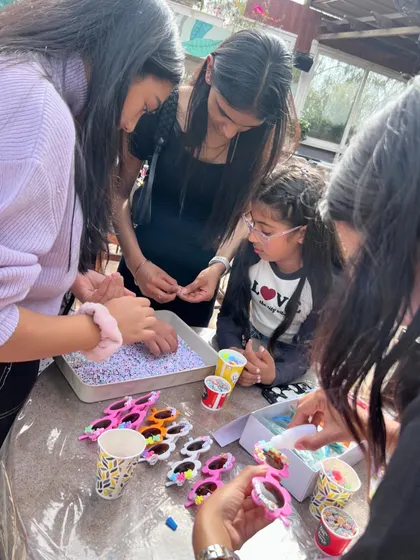 Teamwork makes the dream work! Here, older kids and teens collaborate on decorating funky sunglasses, one of our many craft options perfect for a fun and social birthday activity.