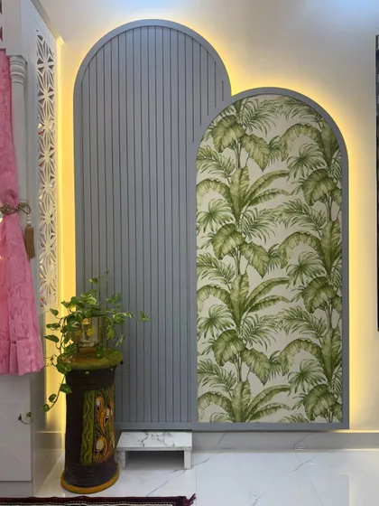 A detail shot of the decorative arched panels next to the pooja unit. The combination of a grey fluted panel and a wallpapered panel, both backlit, adds a modern and artistic touch.