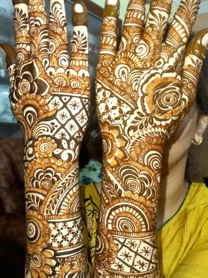 This full-coverage design is a beautiful example of Indo-Arabic art. It features a mix of traditional motifs, including checkerboard patterns, floral bursts, and intricate wristbands.