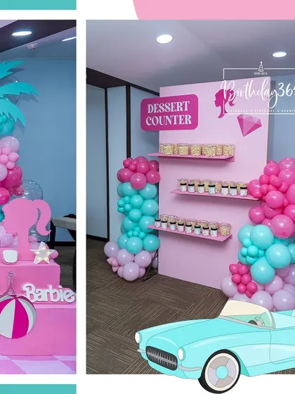 The dessert counter at our Barbie party, complete with themed treats and a pink and teal balloon garland.