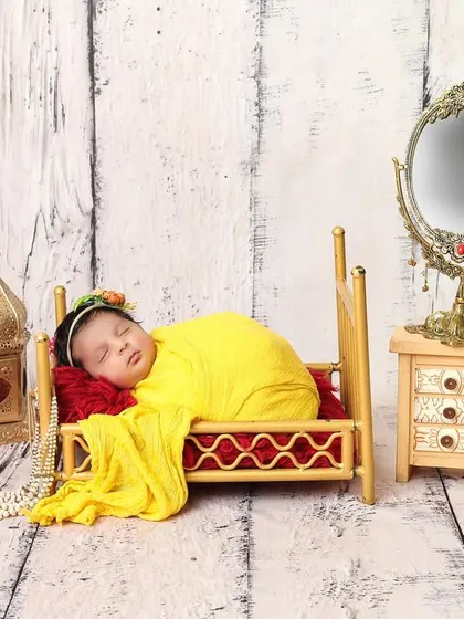 Dreaming in her tiny, elegant bedroom. This setup with a miniature bed and vanity mirror creates a whimsical and precious scene for a sleeping baby girl.