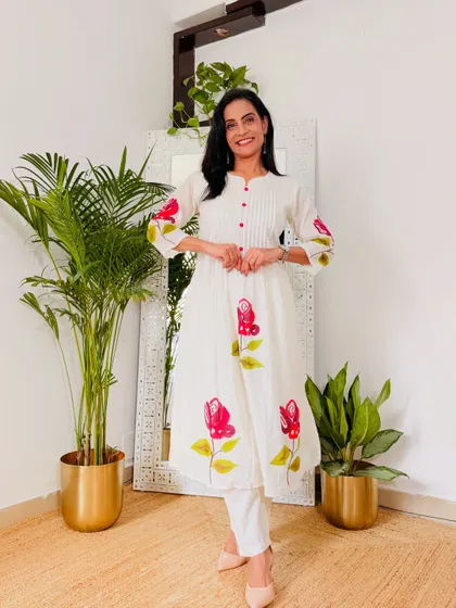 This white kurta pant set with red floral painting is a beautiful and artistic piece. It's a simple Anarkali cut that is very flattering.