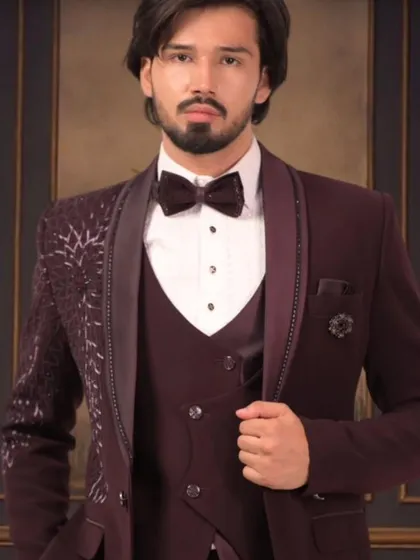 For a sharp reception or party look, we crafted this custom three-piece tuxedo in a rich maroon. Notice the detailed lapel and the perfect fall of the jacket. We make sure every element, from the waistcoat to the bow tie, is stitched to perfection for a modern, confident style.