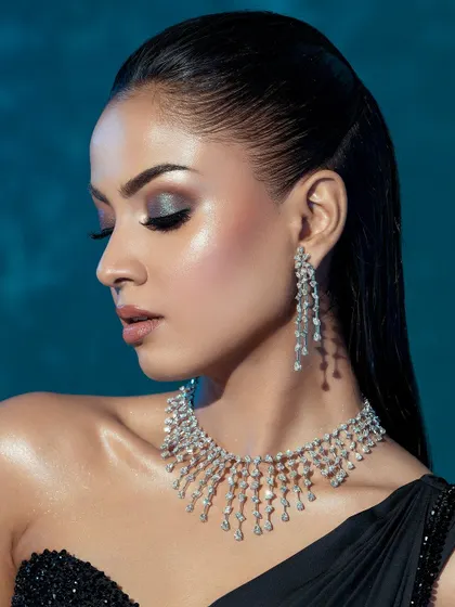 A profile view that showcases the flawless skin, the shimmer of the eyeshadow, and the elegant drop of the diamond earrings.