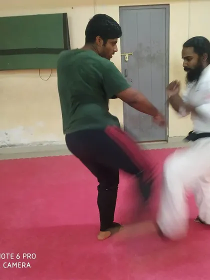 A student practices a low kick against a partner in our dojo. This is a core technique for self-defense, targeting the opponent's leg to disrupt their balance.