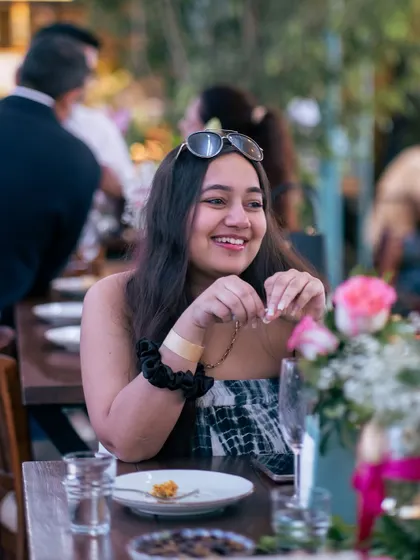 A happy guest at a floral-adorned table. The small details, like fresh flowers, contribute to the overall special feeling of events hosted here.