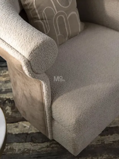A detail shot of the Sienna Curve Armchair, highlighting the tactile contrast between the soft bouclé fabric and the smooth velvet exterior. This combination elevates the overall sensory experience of the piece.