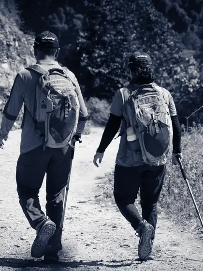 Two trekkers walk side-by-side on a dusty trail, showcasing the companionship and shared experience that defines our guided expeditions.