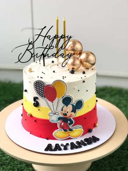 Celebrating a fifth birthday with the one and only Mickey Mouse. This cake features a clean, modern design with Mickey's signature colors and a festive balloon theme.