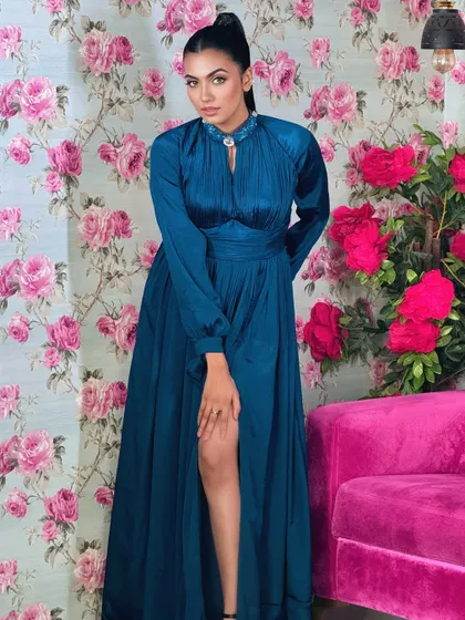 A full-length shot of the teal gown and the sleek high ponytail.