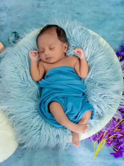 Four weeks of pure love. This setup uses a cool blue backdrop and a pop of purple from the flowers to create a serene and colorful scene.