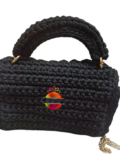 The back view of the black handbag, showing the clean lines and the attachment points for the handle and strap.