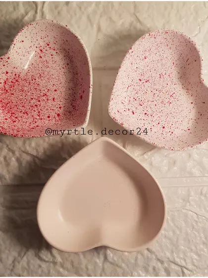 A trio of our mini heart dishes. The top two feature a delicate red splatter effect, while the bottom one is a soft, plain pink, showing the different styles we can create.
